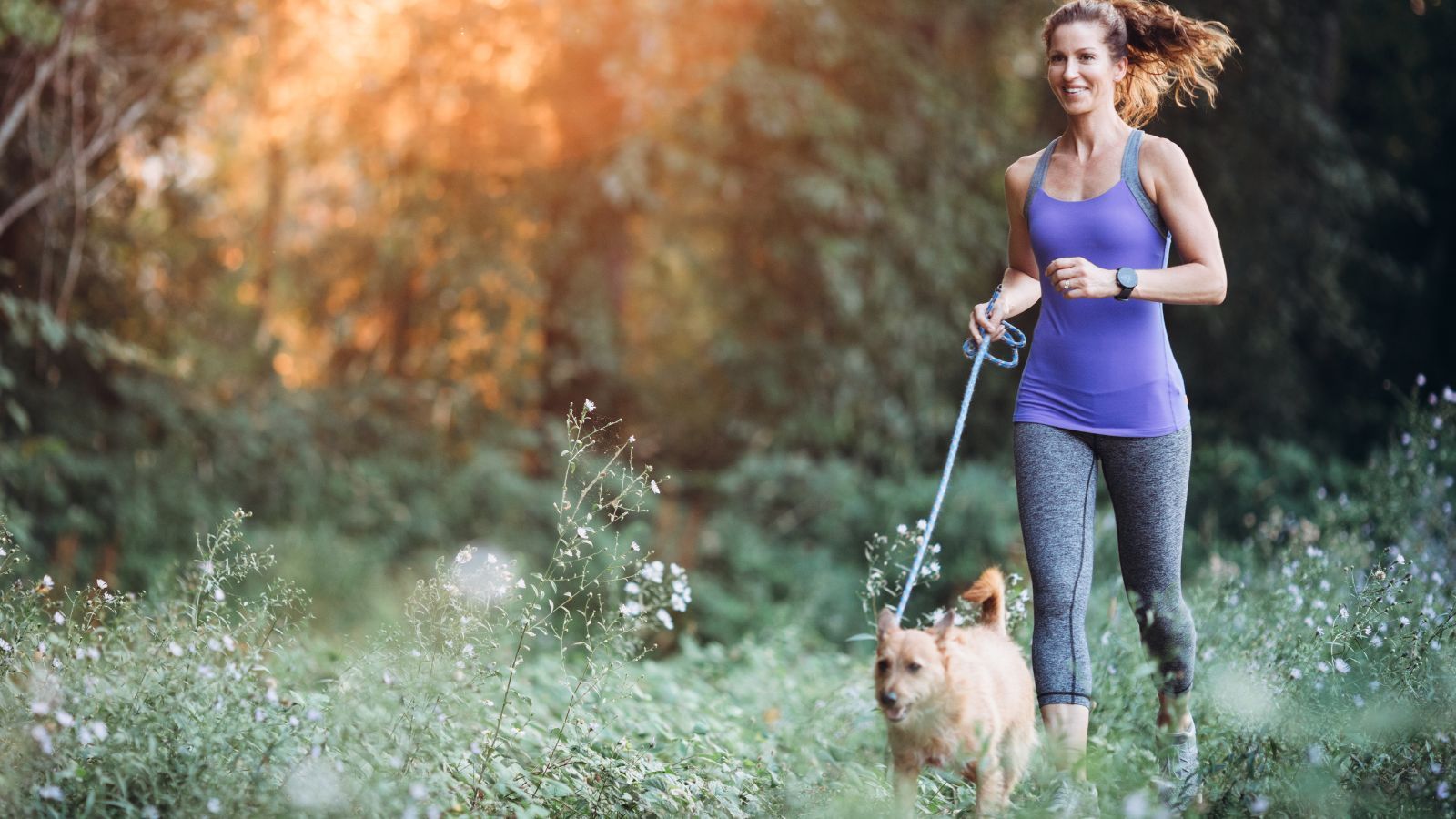 woman jogging with dog on leash